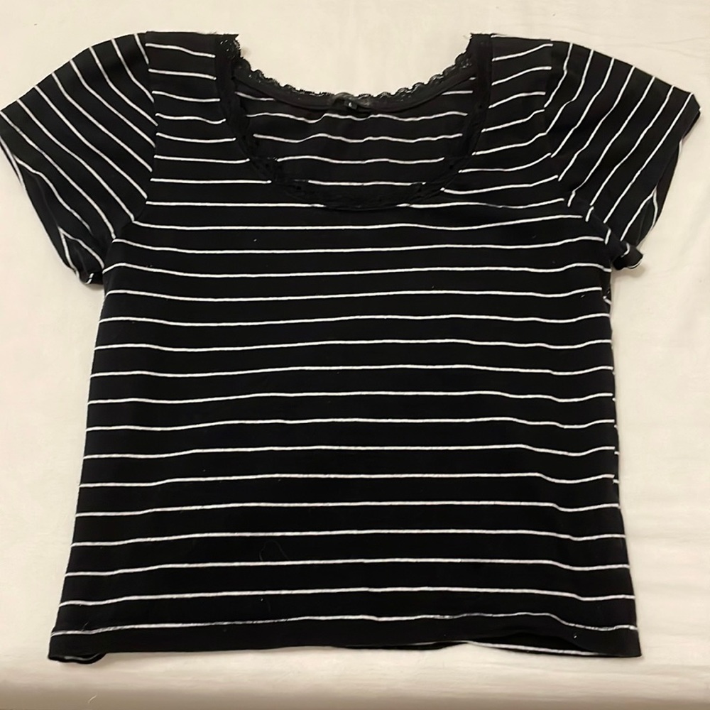 This is a black and white striped shirt and has lace on the collar line